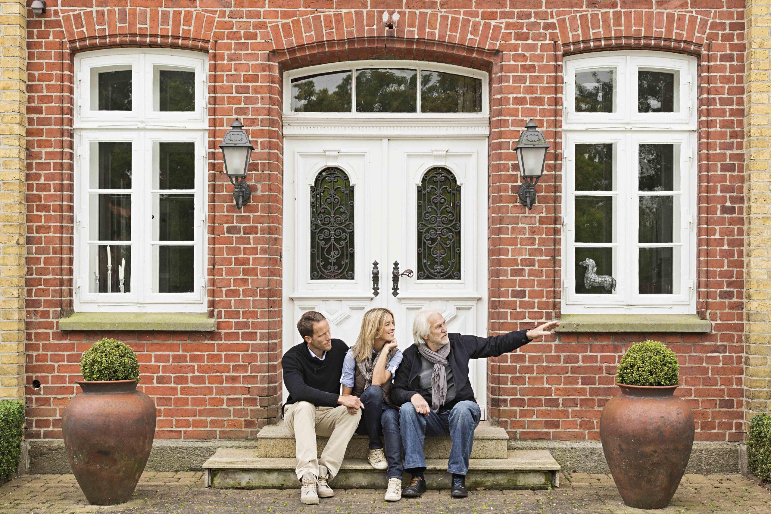 father and mid adult couple sitting on doorstep 2025 04 04 14 25 20 utc scaled